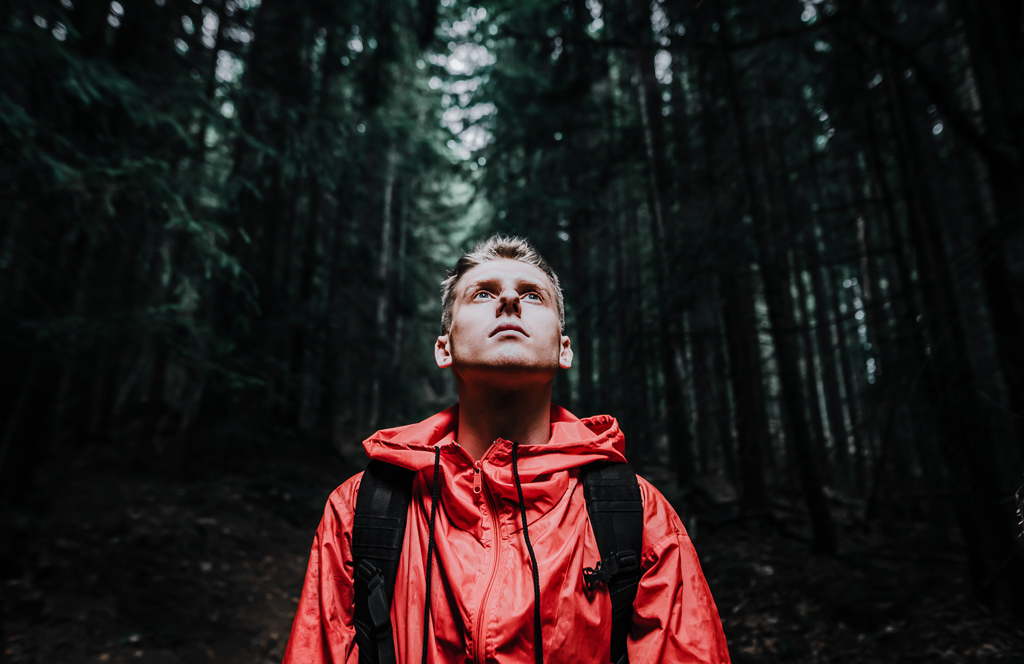 Gatlinburg Explained so you know what to expect - man in red stands in the forest in Gatlinburg with green all around him