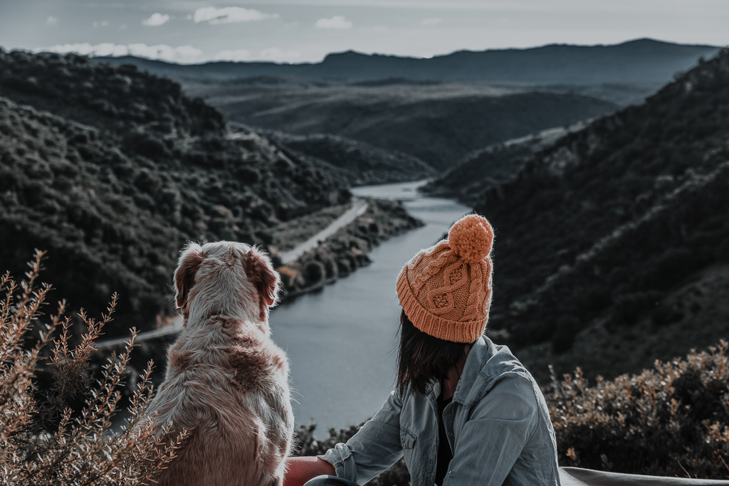 Young girl traveling by nature with backpack and dog